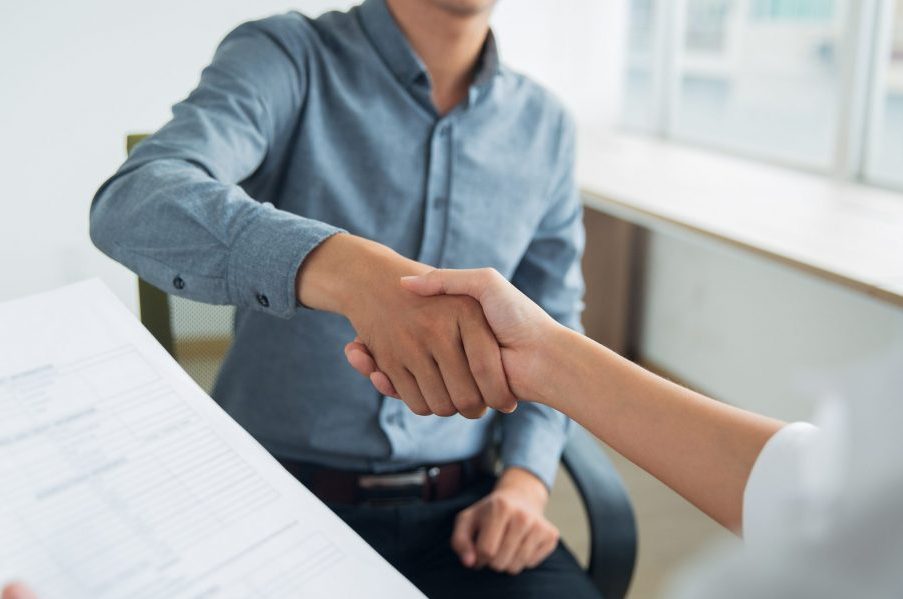 smiling-asian-businessman-shaking-partners-hand-scaled-e1654873341420
